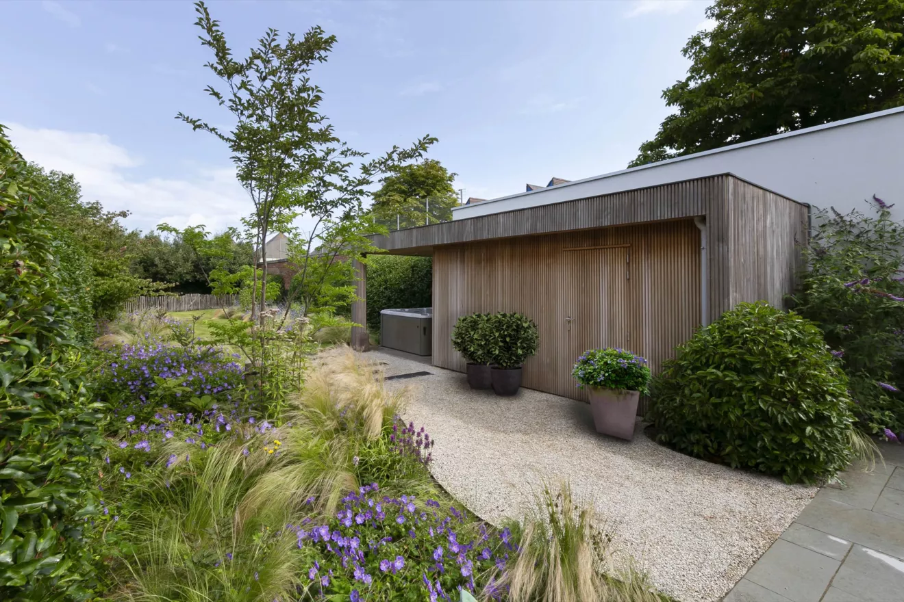 Speelse kusttuin met Dutchborder vol bloemenpracht en tuinberegening te Oostduinkerke (17) -  - Tuinaanleg